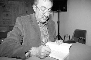 Jesús Quijano firma un ejemplar del libro sobre su vida, el pasado mes de abril, en la presentación del ejemplar en Saldaña. / LUIS SALDAÑA