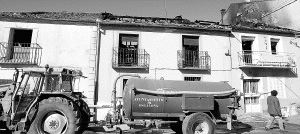 La motobomba municipal ante las fachadas de las viviendas en Escalona del Prado cuyos interiores quedaron arrasados por el incendio declarado en una de ellas. / A. DE TORRE