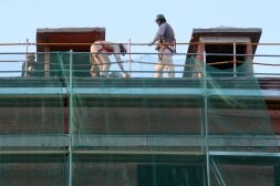 Trabajadores de la construcción sobre la cubierta de un edificio en obras de la capital segoviana. / ANTONIO TANARRO