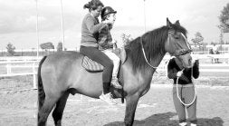Un niño discapacitado y una monitora, montados en un caballo, antes de iniciar el ejercicio./ FOTO CEDIDA POR SERVIMEDIA
