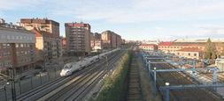 Un tren de alta velocidad pasa entre los terrenos del futuro barrio de Argales, a la derecha, y el barrio de La Rubia./ RAMÓN GÓMEZ