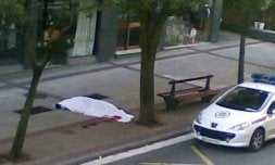 El cadáver del hombre asesinado aparece cubierto por una sábana. / EFE