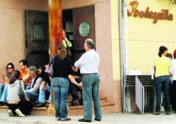 El padre (tercero por la izquierda) recibe el consuelo de sus familiares el día de los hechos. Su hijo murió a escasos metros del bar./ J. S.