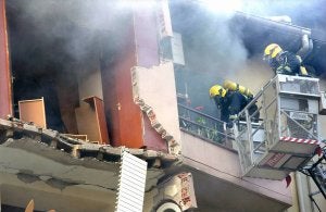 Extinguidas las llamas, los bomberos se afanan en rescatar a los vecinos del inmueble. ::
ABEL ALONSO-EFE