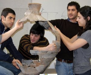 Alumnos de Arquitectura de IE Universidad, con los restos de una vasija hallada en Coca. ::
EL NORTE