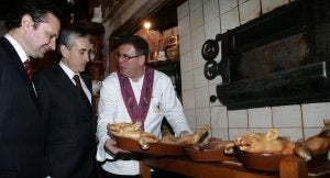 El restaurador Julián Duque muestra unos cochinillos al alcalde Pedro Arahuetes y al ministro Ramón Jáuregui en la visita de ayer. ::                             DE TORRE