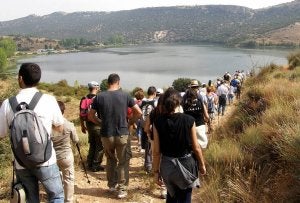 Caminantes descienden por la vereda hacia la orilla del embalse de Las Vencías. ::
ELENA RUBIO