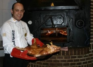 El maestro asador del restaurante arevalense Siboney, Javier Rodríguez de la Iglesia, muestra un tostón recién salido del horno. ::
F. G. M.