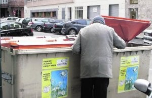 Un hombre rebusca en un contenedor en la calle Padilla. ::                             RAMÓN GÓMEZ