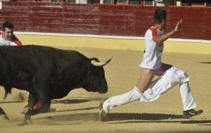 Javier Asenjo 'Quisquilla' corre delante del toro, después de que éste le bajara los pantalones con un asta. ::                             FOTOGRAFÍAS DE FRAN JIMÉNEZ