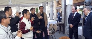 Varios turistas de Sanghai toman fotografías de Cándido y Alberto López, ayer junto al busto del mesonero. ::                             ANTONIO DE TORRE