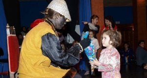 Una niña recibe una bolsa de caramelos de un paje. :: J. HERNANDO