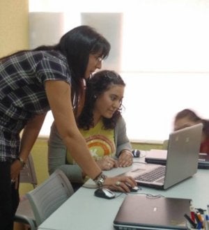 Una monitora ayuda a una alumna frente al ordenador. ::
EL NORTE