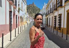 María Julia Marín sujeta una copa de vino con el castillo de Miraflores como telón de fondo.