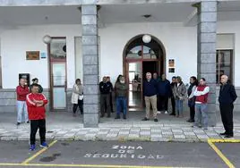 Asistentes al minuto de silencio guardado en la puerta del Ayuntamiento de Alconchel este lunes.