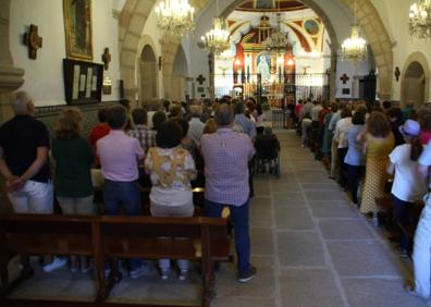 Imagen secundaria 1 - Numerosos fieles acudieron a la cita. En la tercera foto, Juan Antonio Cruz, Mayordomo de la Cofradía, hace entrega del jamón a la agraciada. 