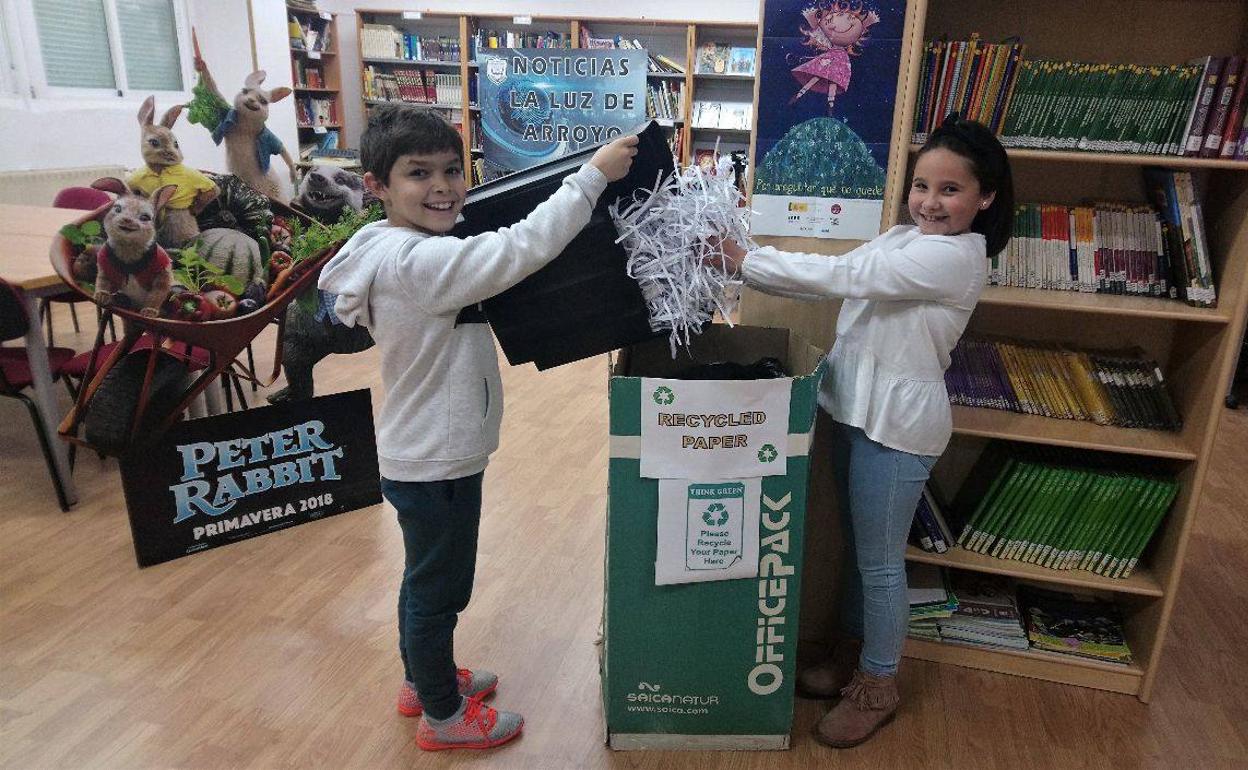 Dos alumnos colaborando en el reciclado de papel del centro. 