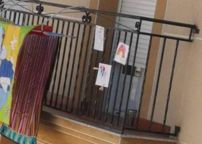Imagen secundaria 1 - Los pequeños adornan los balcones y se dan ánimos unos a otros.