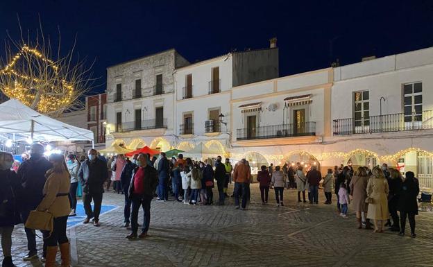 Imagen principal - Un gran número de vecinos paseando entre los puestos. Debajo, parte de la corporación municipal que se acercaron hasta la plaza. 