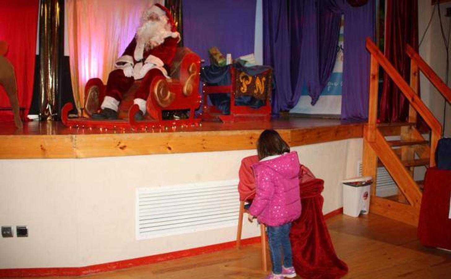 Una niña entregando su carta a Papá Noel.