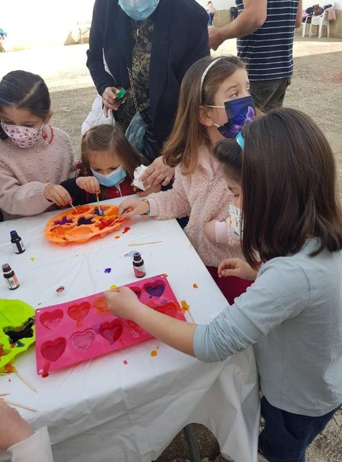 Varias pequeñas elaborando jabones.