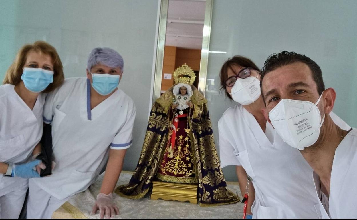 José Manuel Lucas, con tres compañeras junto a la imagen de la virgen. 