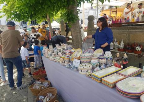 Imagen secundaria 1 - Una niña en un taller de demostración de torno. Debao, uno de los puestos de alfarería de la feria.