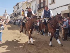Dos jinetes bajan a galope por La Corredera.