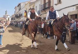 Dos caballistas bajando a galope la Corredera.