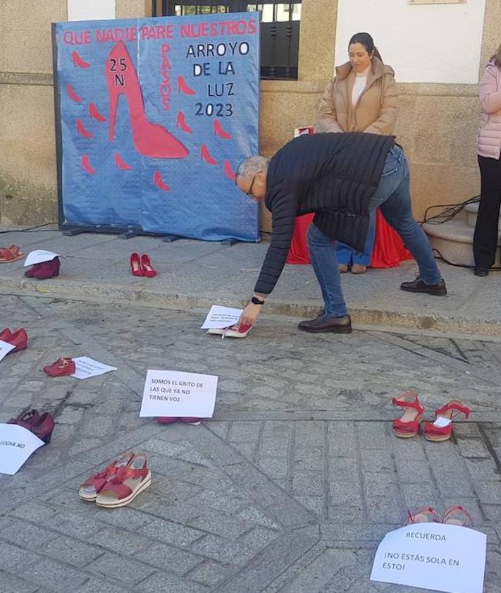 Imagen secundaria 2 - El alcalde local, Carlos Caro, también colocó su frase encima de un par de zapatos rojos tras la lectura del manifiesto.