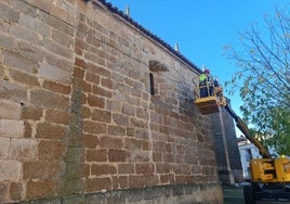 Operarios del Ayuntamiento colocando la iluminación en la fachada de la iglesia.