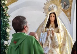 Imagen de archivo. Juan Manuel García, párroco de la localidad, presentando a un bebé a la Virgen de la Luz.