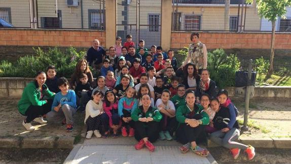 Jugadoras y técnico del Extremadura Arroyo junto a 4º de primaria del CEIP Ntra. Sra. de la Luz, la coordinadora local del programa y representantes de la AMPA del centro