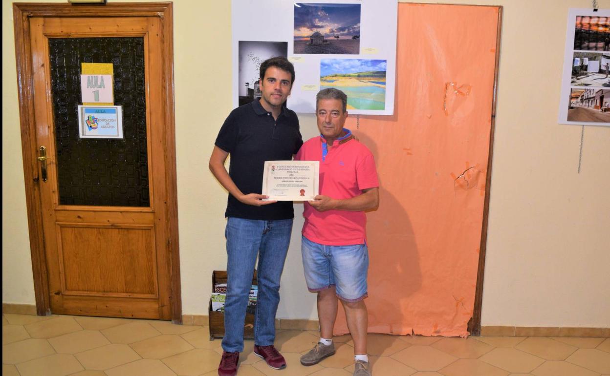 El concejal de Cultura entrega el premio a la fotografía ganadora. 