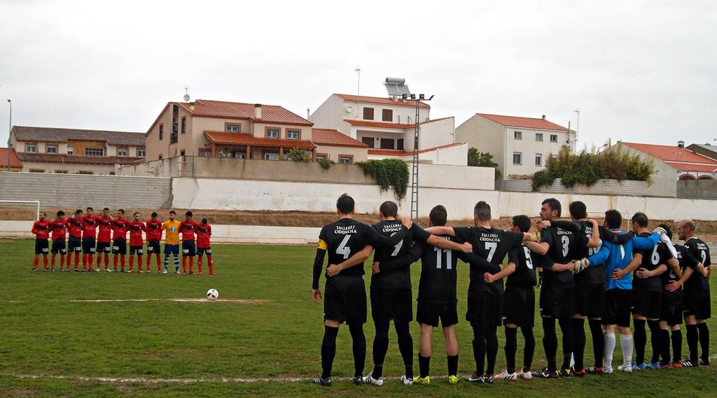 Los dos equipos durante el minuto de silencio. 