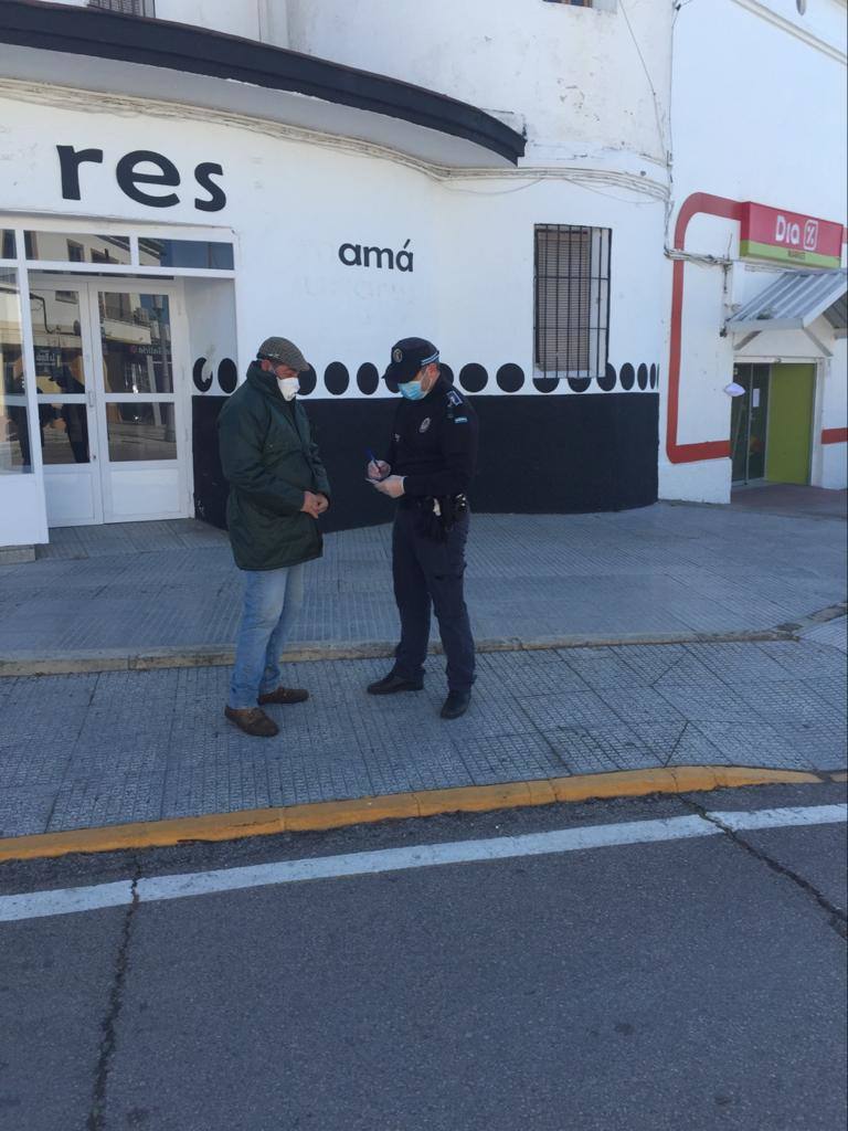 Un agente identifica a un vecino que transita por la calle para sabe a dónde se dirige. 