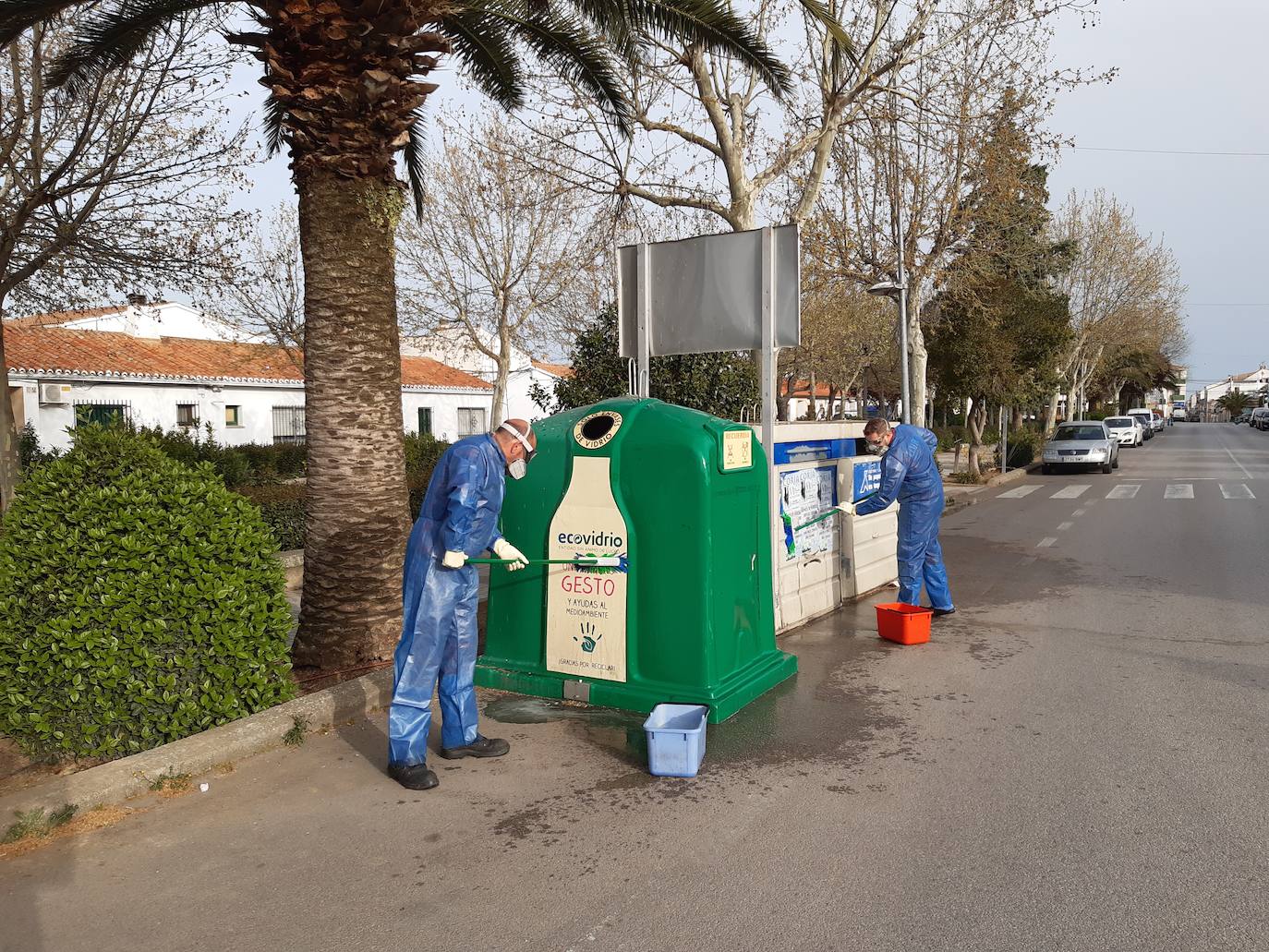 Dos trabajadores limpian ya contenedores, bancos y papeleras del Paseo de Extremadura. 