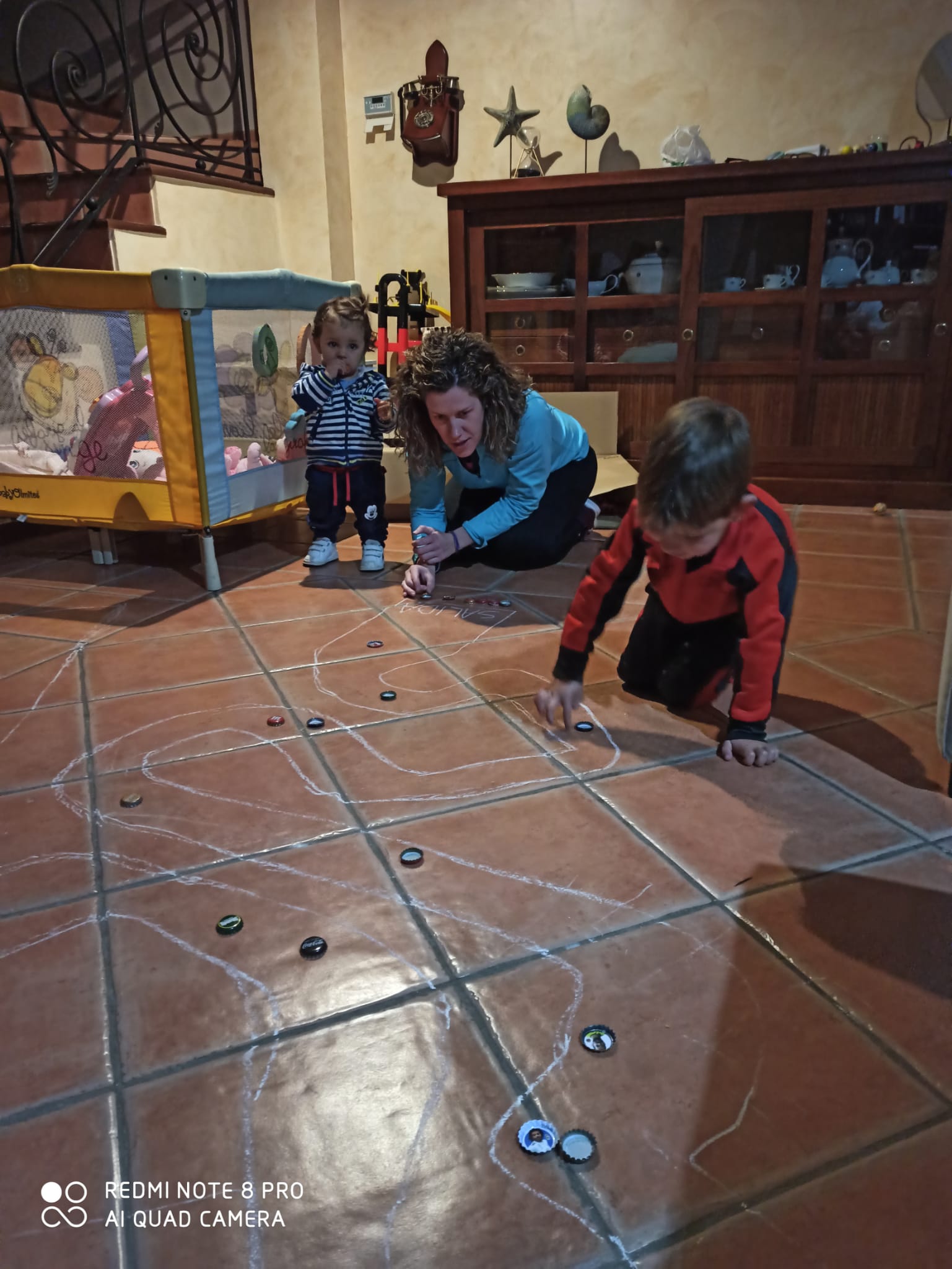 Soledad María Granados juega con sus hijos a la carrera de chapas. 