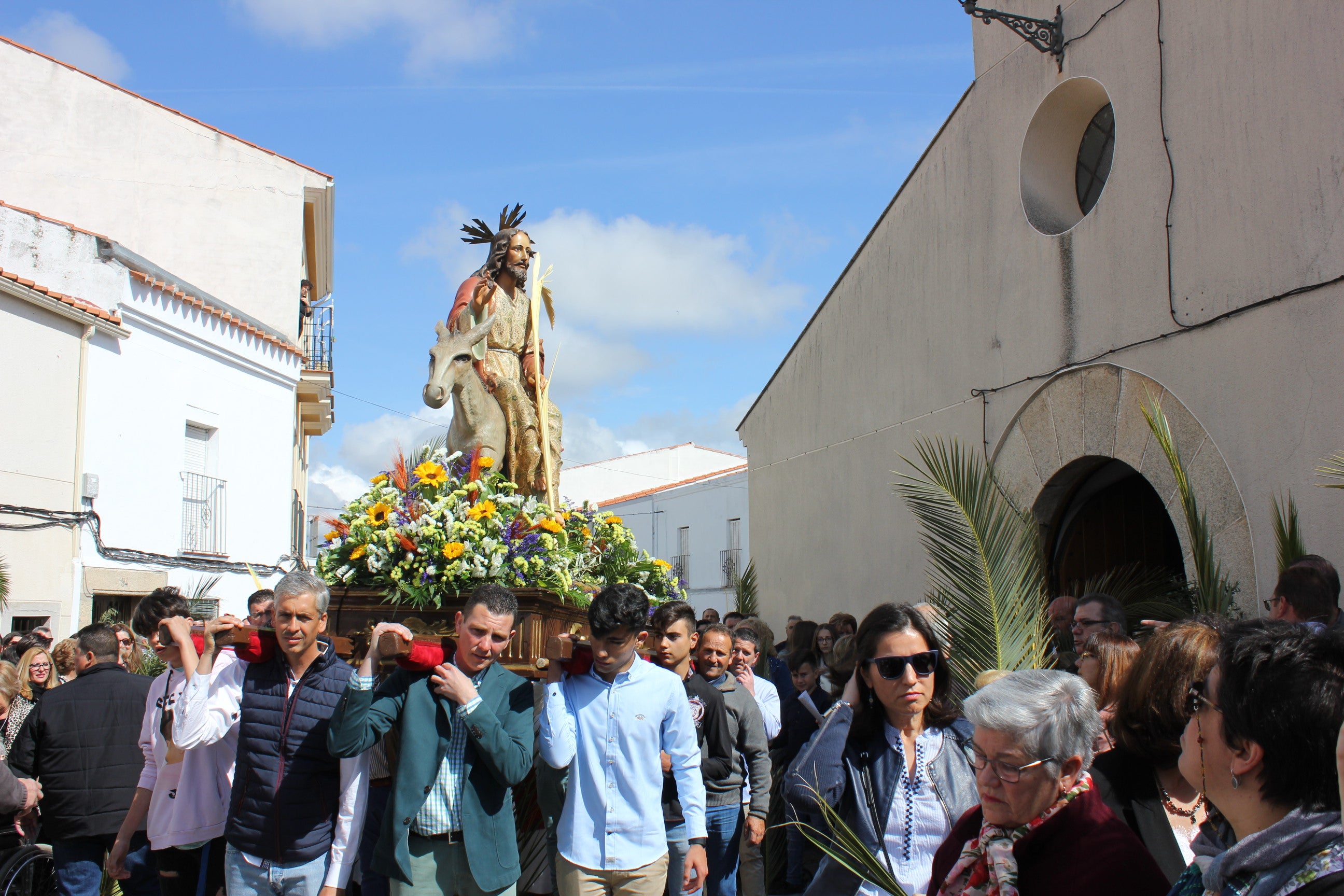 Imagen secundaria 1 - Contraste de imágenes de la celebración del pasado año, con la procesión de la Burrina, a la de este año, con niños sacando los ramos a sus ventanas, y la Policía entregándo algunos por los hogares. CEDIDAS