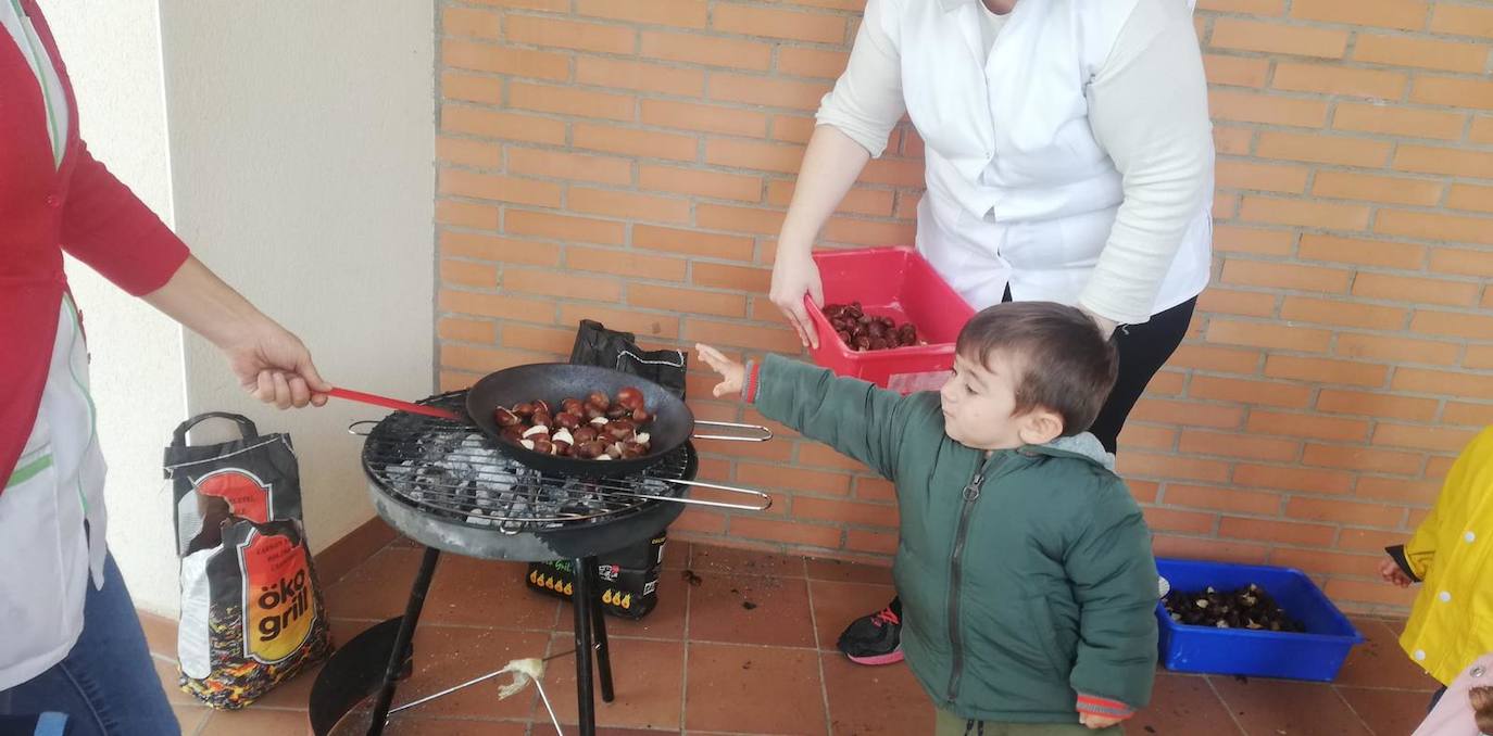 Un niño disfruta dejando castañas sobre la pequeña barbacoa de su centro. 