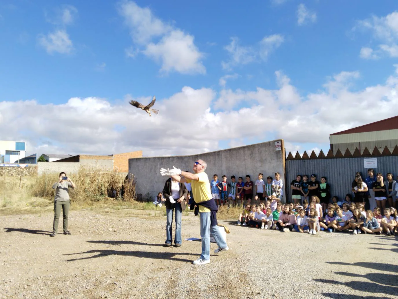 Un maestro, amante de la ornitología, libera a uno de los cernícalos en presencia de los alumnos.