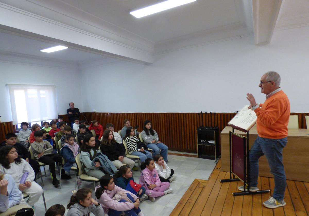 El alcalde, junto al ejemplar de la Constitución, dirigiéndose a los escolares.