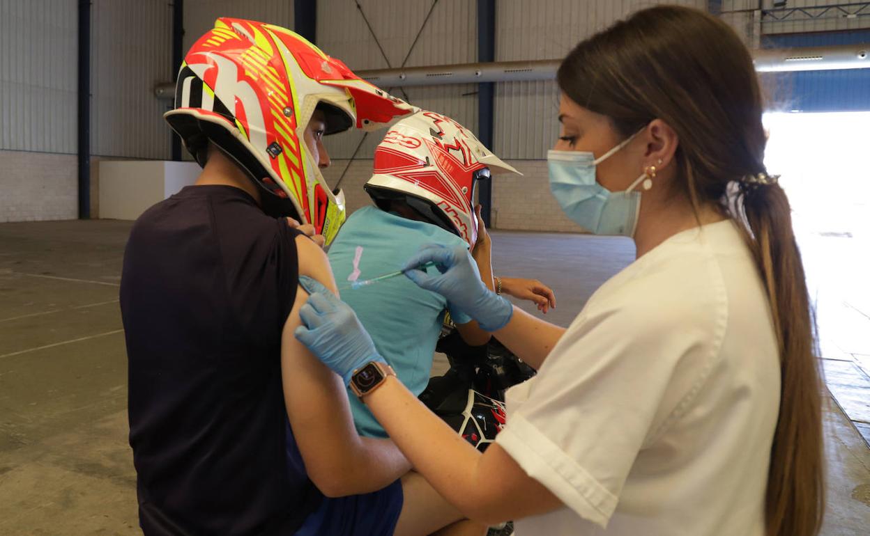 Jóvenes en moto acuden a su cita para la segunda dosis. 
