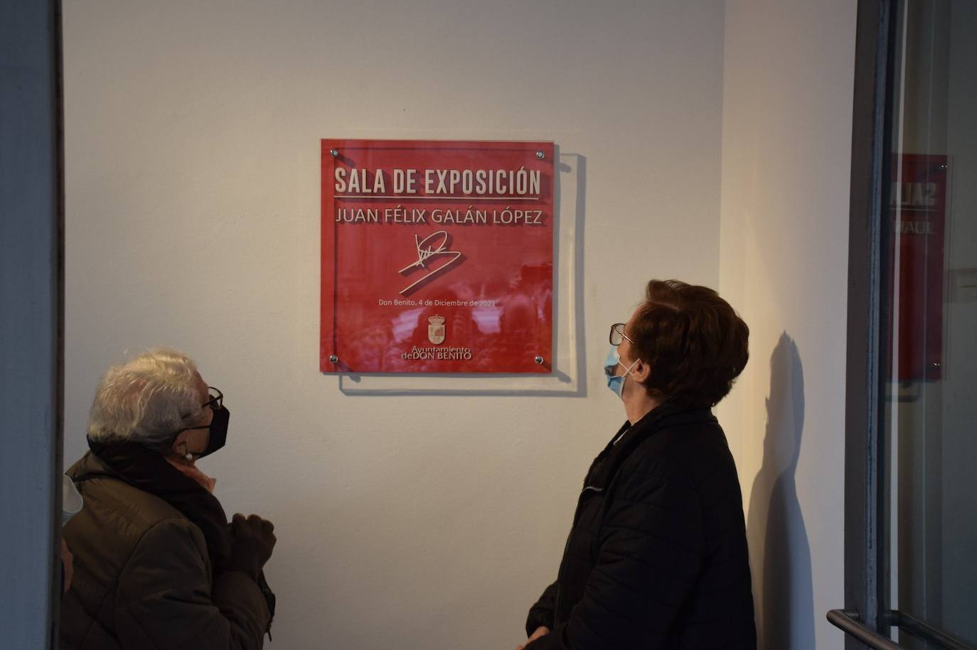 Familiares junto a la placa con su nombre en la casa de cultura. 
