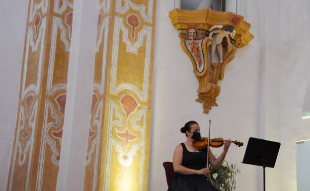 La violinista enmarcada por la hermosa decoración de la iglesia 