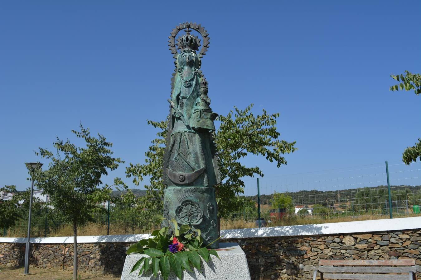 Flores frescas a los pies de la figura de bronce. ALBERTO MÁRQUEZ