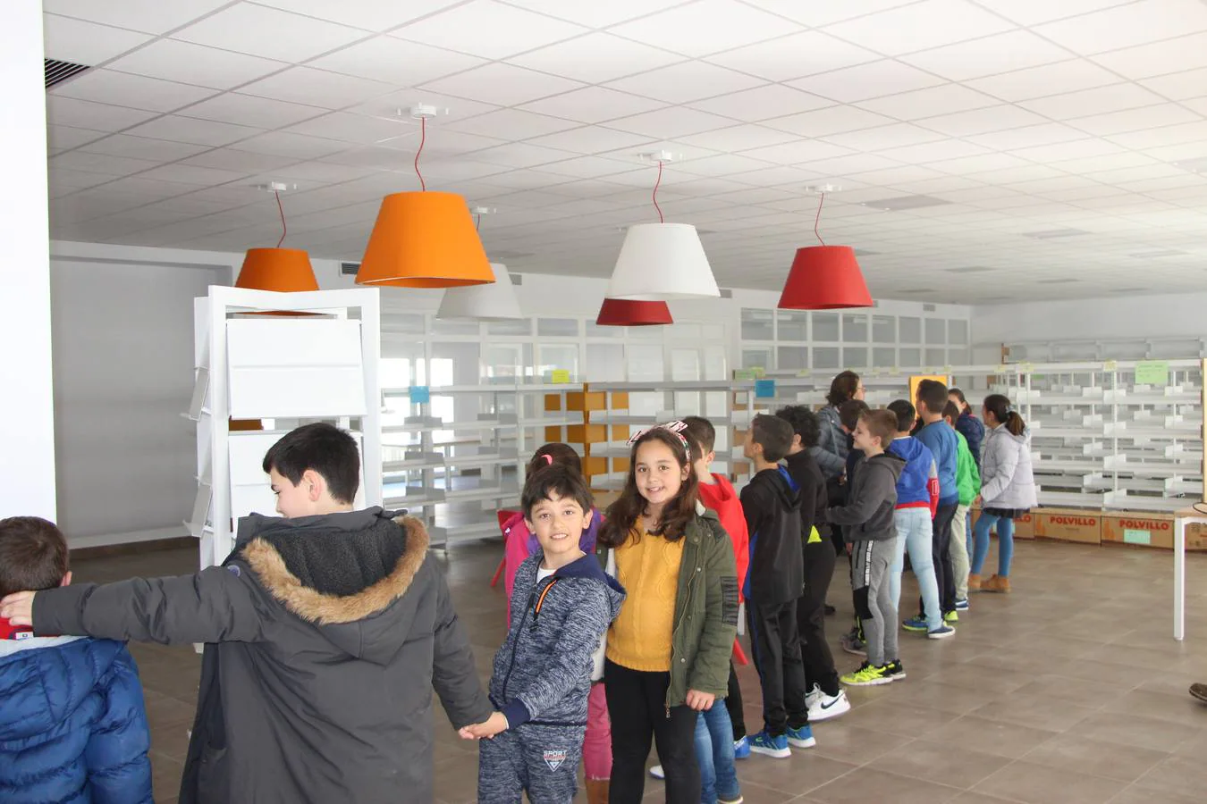 Los niños hacen una cadena humana para el traslado a la nueva biblioteca.