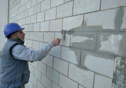 Alumno trabajando en la pared del pabellón deportivo La Encina.