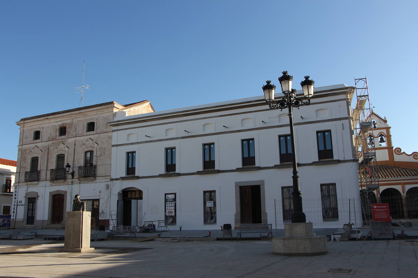 Panorámica frontal del hotel rural flanqueado por lo que será Centro de Interpretación Tarteso e iglesia de San Gregorio-