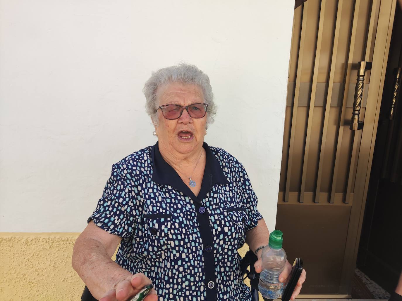 Antonia explicando su historia de los dos nombres en la puerta de su casa, sentada en su andador.